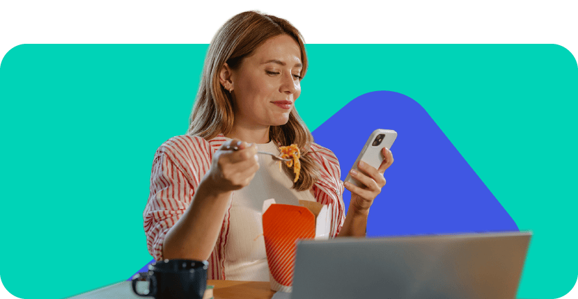 krāsains attēls, kurā sieviete sēž pie galda, skatās telefonā un ēd nūdeles